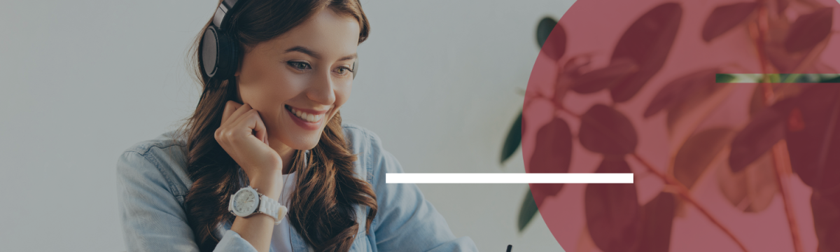 Woman wearing headphones smiles at laptop screen